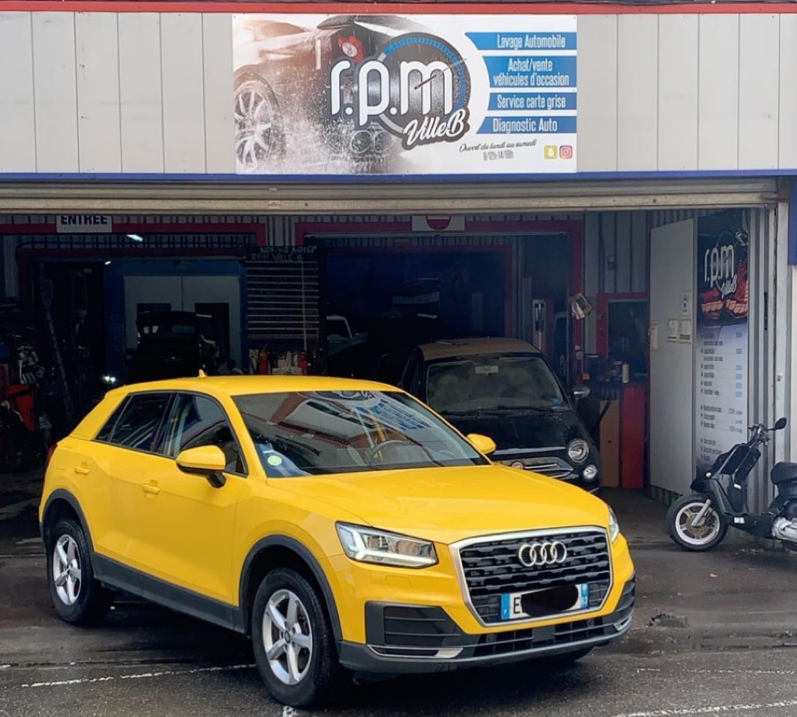 Audi Q2 jaune devant l'atelier